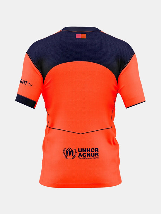 Back of Kids Barcelona 25/26 Third jersey in orange/navy with UNHCR ACNUR logo